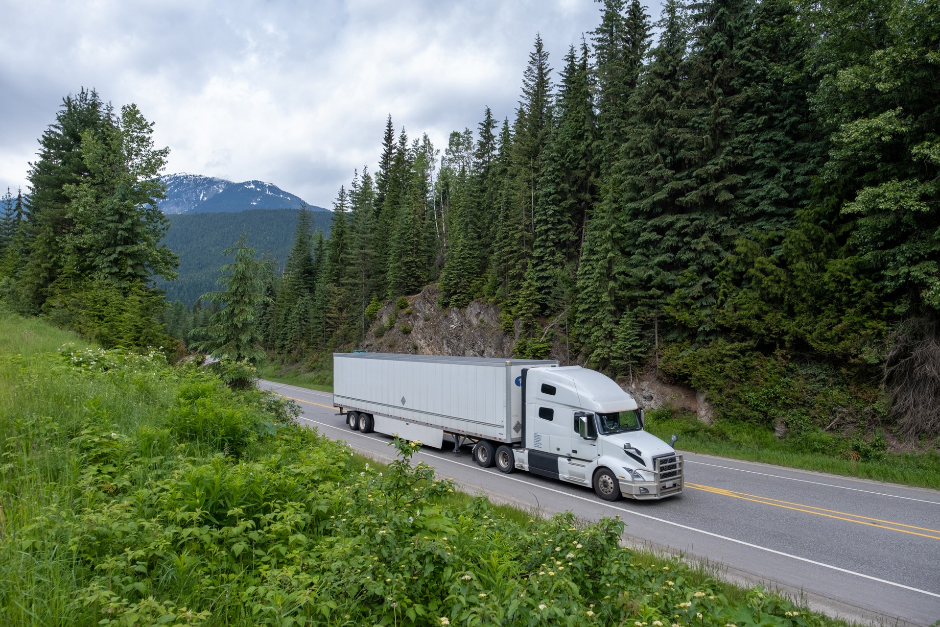 Container truck along a scenic road through the Canadian Rockies